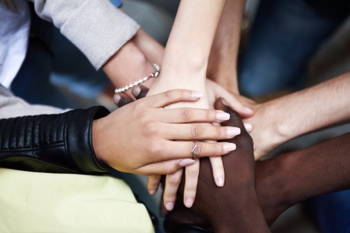top-view-young-people-putting-their-hands-together People holding hands